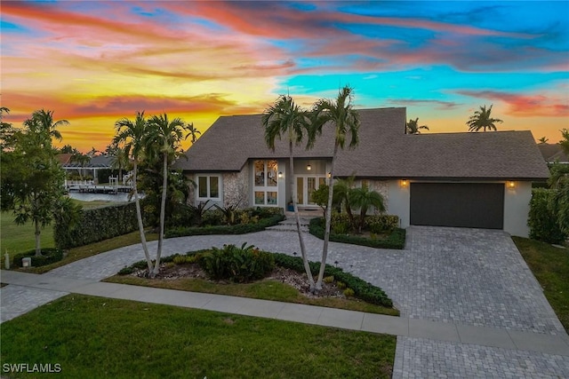 view of front of home with a garage and a lawn