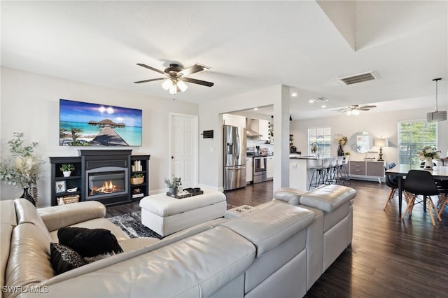 living room with dark hardwood / wood-style flooring and ceiling fan