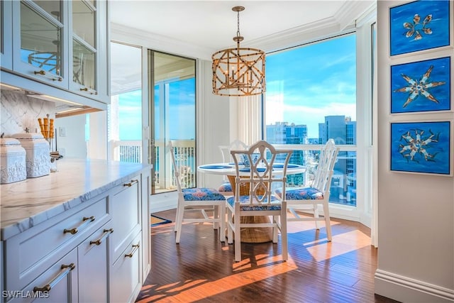 dining area with a notable chandelier, dark hardwood / wood-style floors, and crown molding