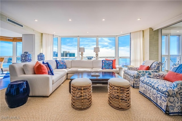 living room featuring floor to ceiling windows, a water view, and plenty of natural light