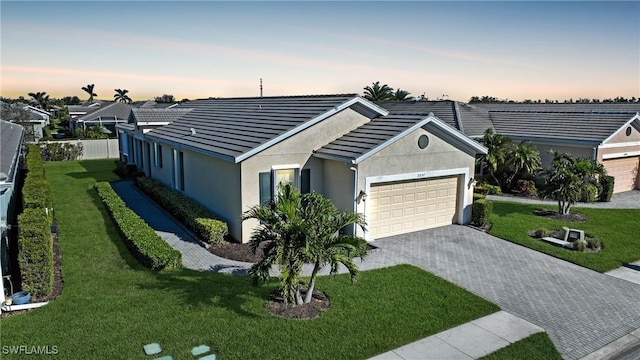 ranch-style home with a yard and a garage