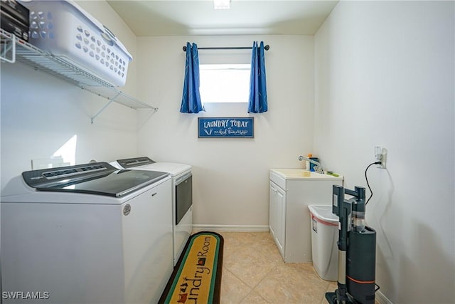 laundry room with sink, light tile patterned floors, cabinets, and independent washer and dryer