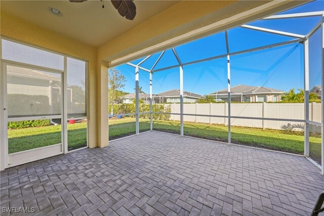 unfurnished sunroom with ceiling fan