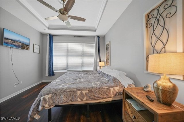 bedroom featuring a tray ceiling, ceiling fan, dark hardwood / wood-style flooring, and crown molding