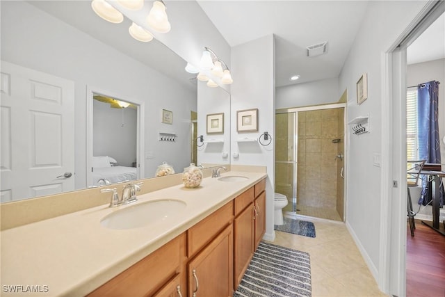 bathroom with tile patterned floors, vanity, toilet, and a shower with door