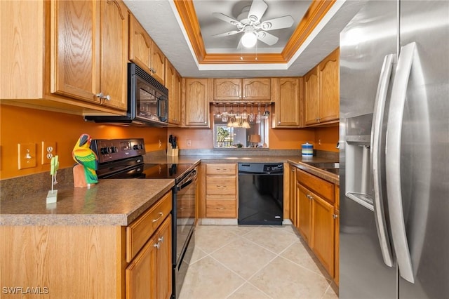 kitchen with a raised ceiling, ceiling fan, crown molding, black appliances, and light tile patterned floors