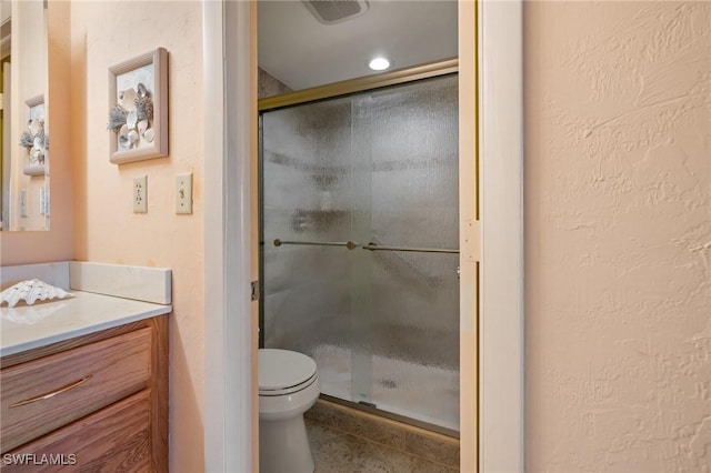 bathroom with tile patterned flooring, vanity, toilet, and walk in shower