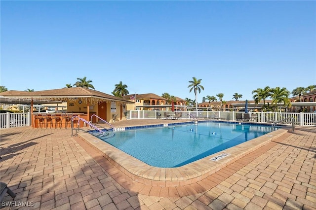 view of pool with a bar and a patio