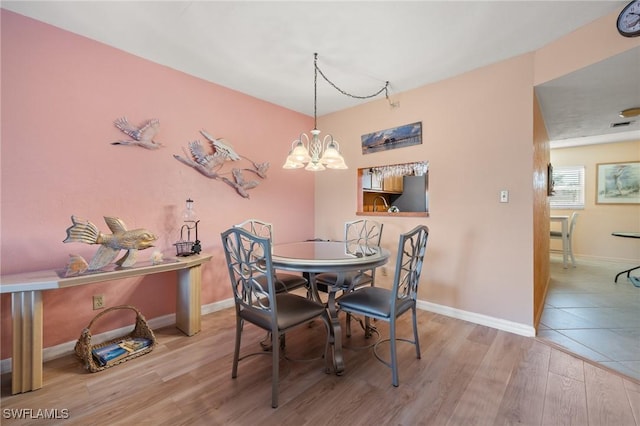 dining area featuring a chandelier and light hardwood / wood-style flooring