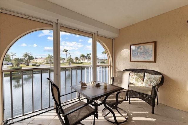 sunroom / solarium with a water view and a healthy amount of sunlight