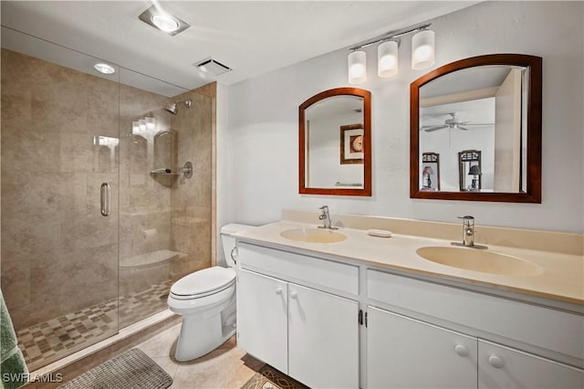 bathroom with vanity, toilet, a shower with shower door, and tile patterned flooring