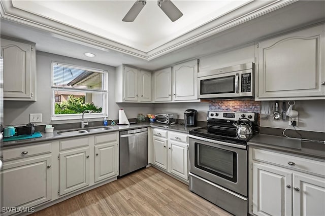 kitchen featuring sink, light hardwood / wood-style floors, white cabinets, and appliances with stainless steel finishes