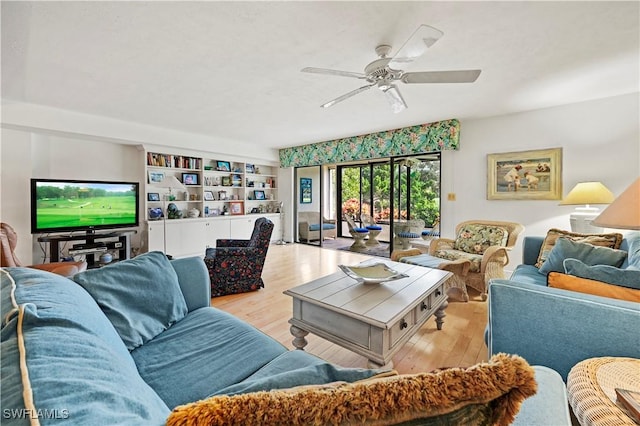 living room with built in features, light hardwood / wood-style floors, and ceiling fan