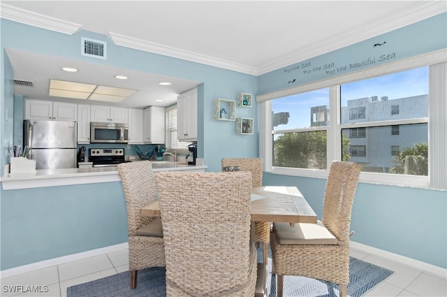 dining room with plenty of natural light, ornamental molding, and light tile patterned flooring