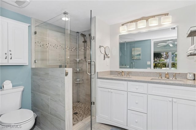 bathroom with ceiling fan, toilet, an enclosed shower, and vanity