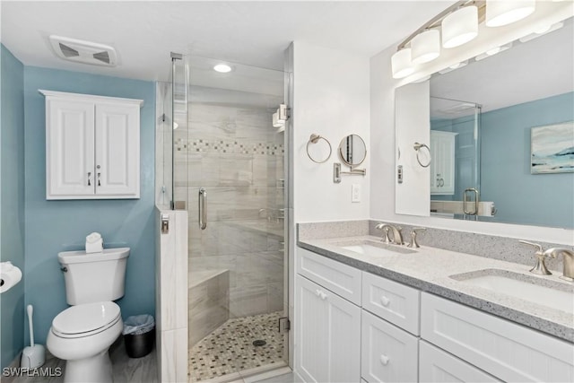 bathroom with vanity, a shower with shower door, and toilet