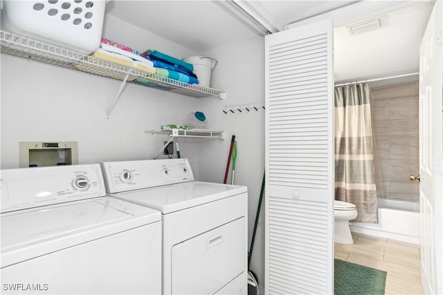 laundry area featuring washer and dryer and light hardwood / wood-style flooring