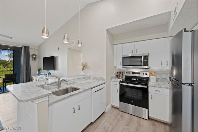 kitchen with kitchen peninsula, appliances with stainless steel finishes, decorative light fixtures, light hardwood / wood-style flooring, and white cabinets