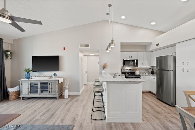 kitchen with white cabinetry, hanging light fixtures, stainless steel appliances, kitchen peninsula, and a breakfast bar