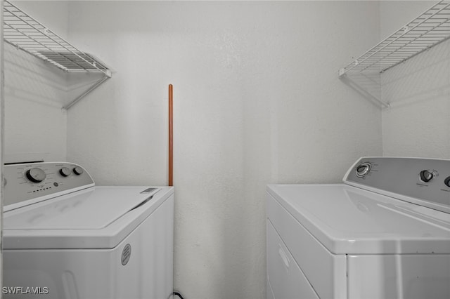 clothes washing area with washer and clothes dryer