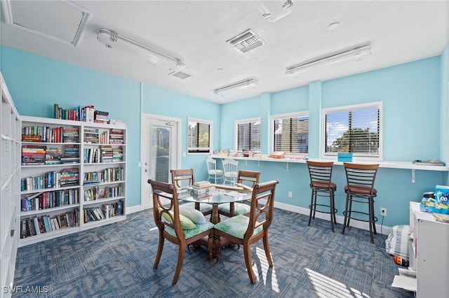 dining area featuring dark carpet