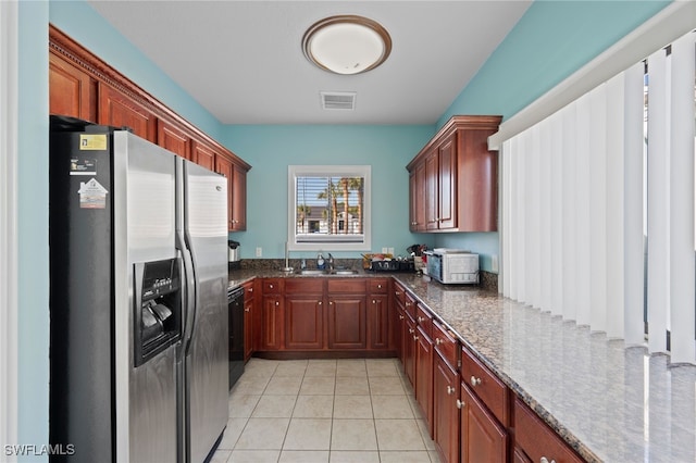 kitchen featuring sink, light tile patterned floors, dark stone countertops, stainless steel fridge with ice dispenser, and black dishwasher