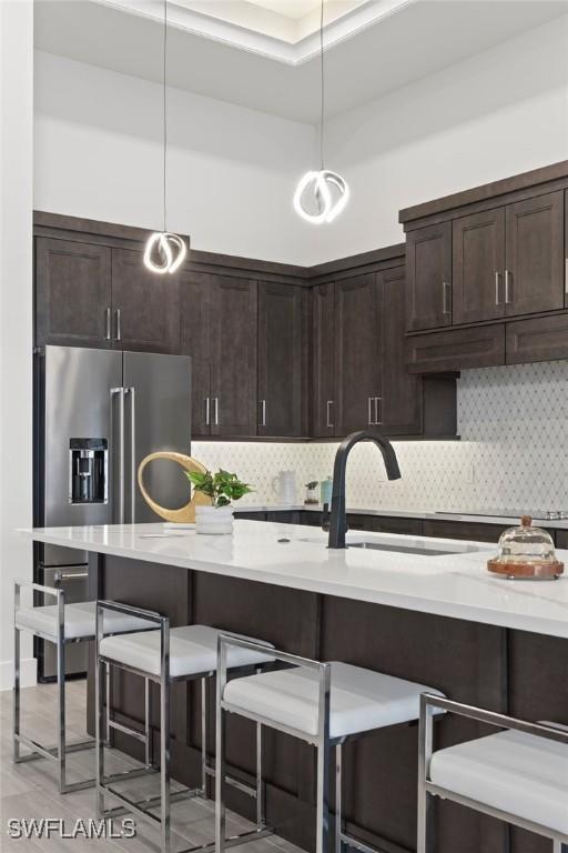 kitchen featuring high quality fridge, decorative backsplash, and decorative light fixtures