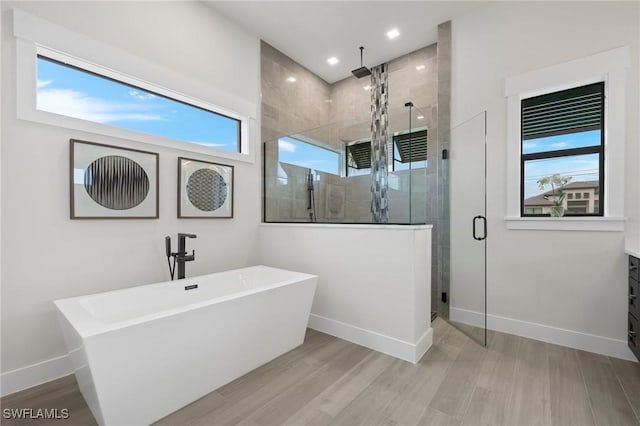 bathroom with hardwood / wood-style floors, vanity, separate shower and tub, and a healthy amount of sunlight