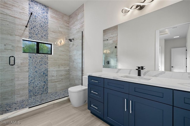 bathroom featuring toilet, vanity, wood-type flooring, and walk in shower