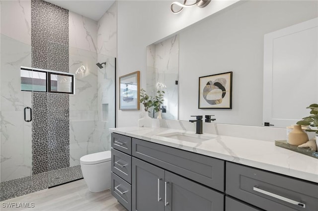 bathroom with vanity, wood-type flooring, an enclosed shower, and toilet