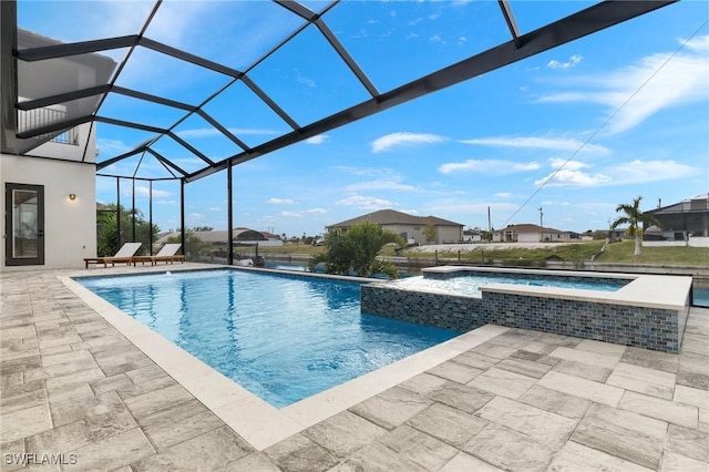 view of swimming pool with glass enclosure, an in ground hot tub, and a patio