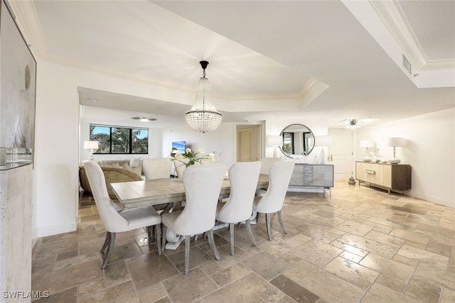 dining area with a chandelier, a tray ceiling, and ornamental molding