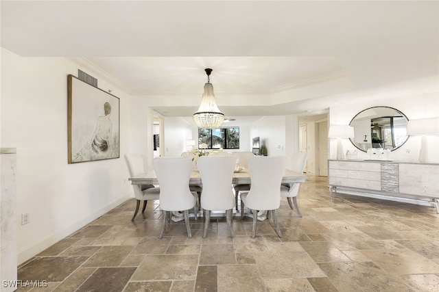 dining room with a raised ceiling, crown molding, and a chandelier