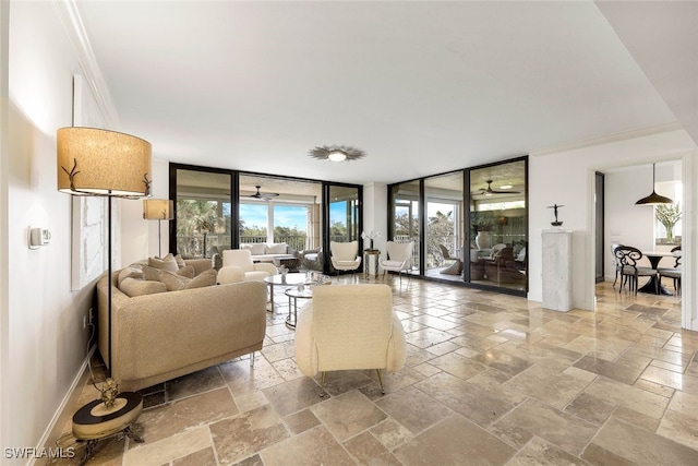 living room with a wealth of natural light, ceiling fan, ornamental molding, and a wall of windows