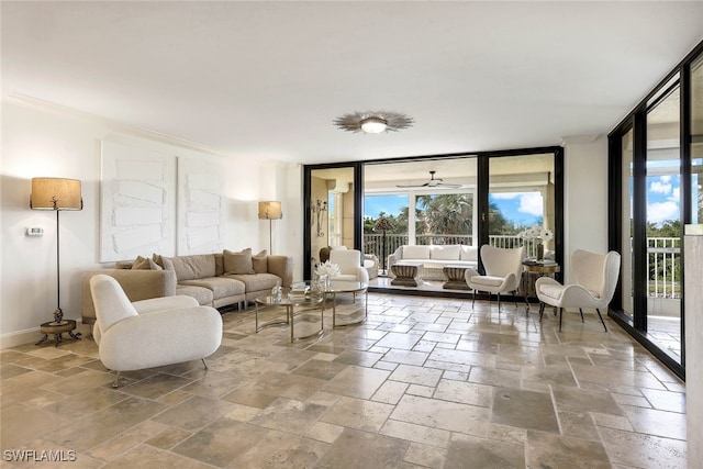 living room featuring a wealth of natural light, ceiling fan, and a wall of windows