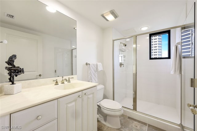 bathroom featuring vanity, toilet, and a shower with door