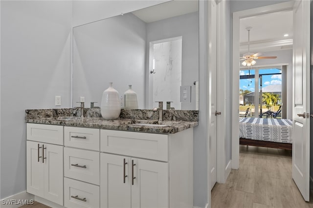 bathroom with wood-type flooring, vanity, and ceiling fan