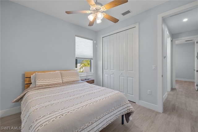 bedroom with ceiling fan, light hardwood / wood-style flooring, and a closet