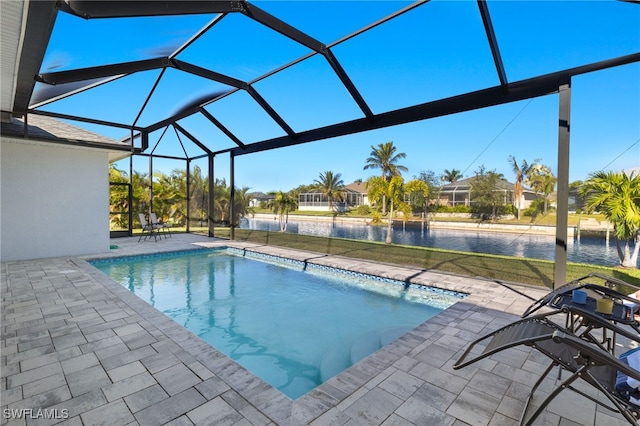 view of pool featuring glass enclosure, a water view, and a patio