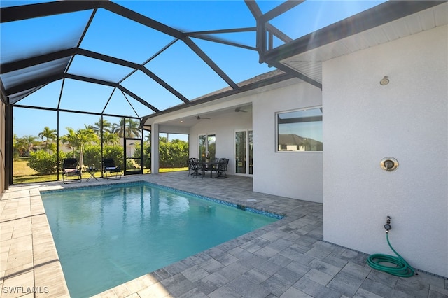 view of swimming pool with a lanai, ceiling fan, and a patio