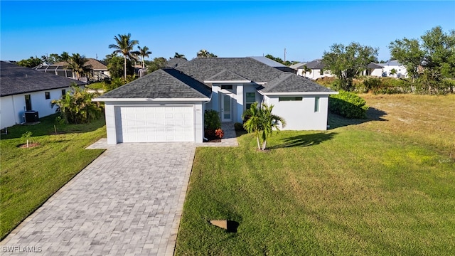 view of front of home featuring central AC unit, a garage, and a front yard