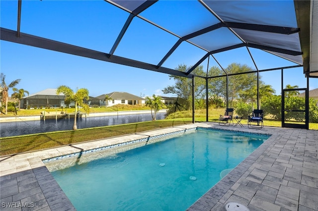 view of swimming pool featuring glass enclosure, a patio area, a water view, and a yard