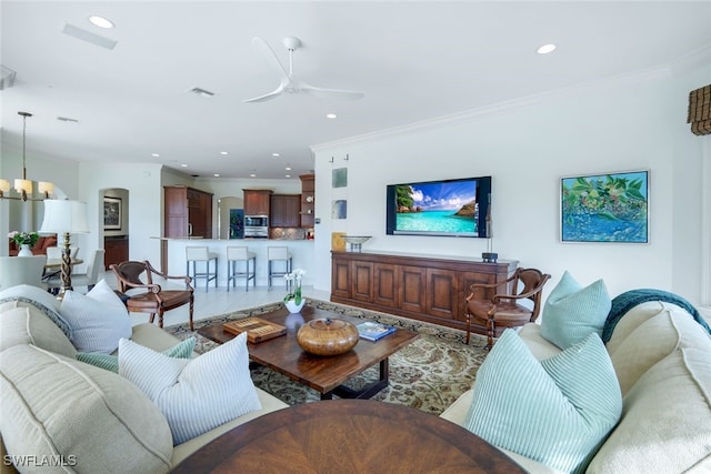 living room featuring ceiling fan with notable chandelier and crown molding