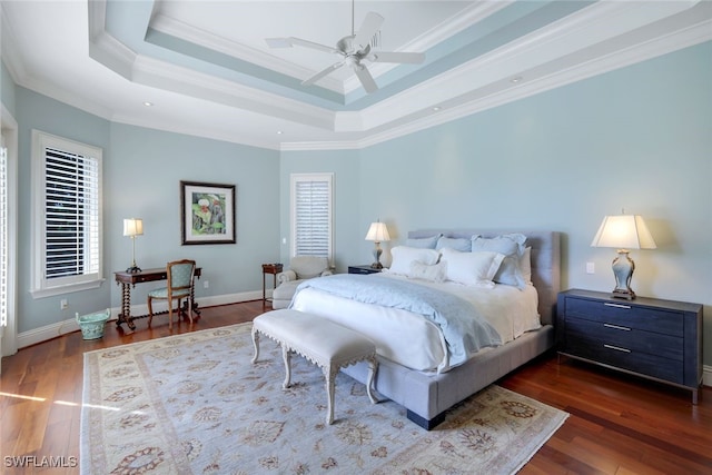 bedroom with a raised ceiling, crown molding, dark hardwood / wood-style flooring, and ceiling fan