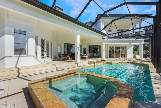 view of swimming pool with pool water feature, a patio area, a lanai, and an in ground hot tub