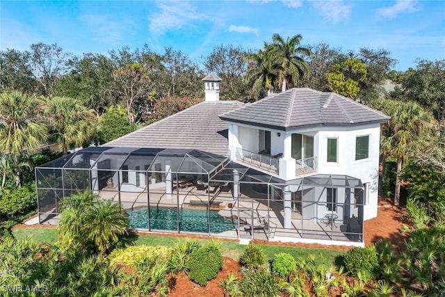 rear view of house featuring a patio, a balcony, and a lanai