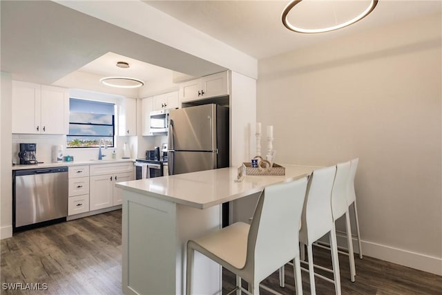 kitchen featuring white cabinets, dark hardwood / wood-style floors, and appliances with stainless steel finishes