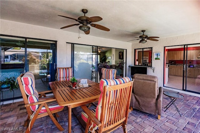 sunroom / solarium featuring ceiling fan