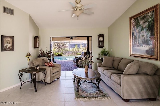 tiled living room featuring ceiling fan and vaulted ceiling