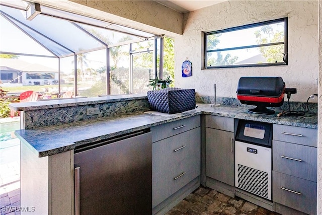 view of patio / terrace with a lanai and exterior kitchen